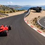 Una monoposto rossa corre su una pista che diventa un cavo scollegato, accanto a una strada alternativa.